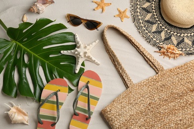 Different beach accessories on sand, flat lay Photo of Different beach accessories on sand, flat lay