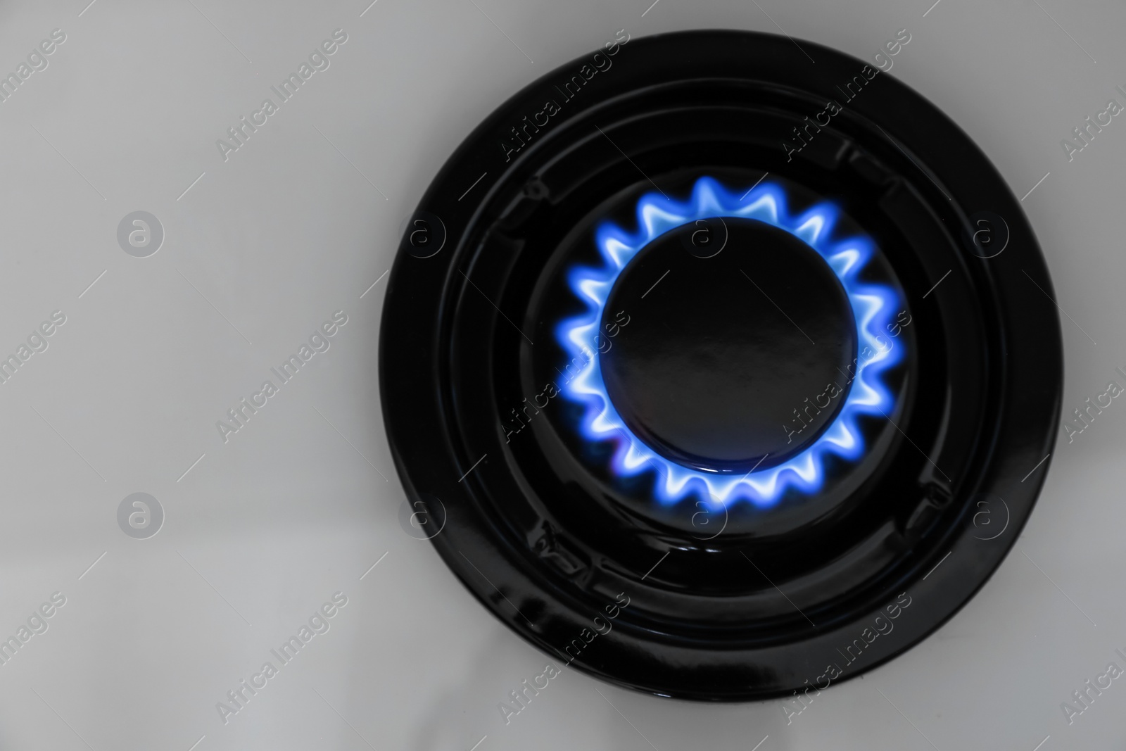 Gas burner of modern stove with burning blue flame, top view Photo of Gas burner of modern stove with burning blue flame, top view
