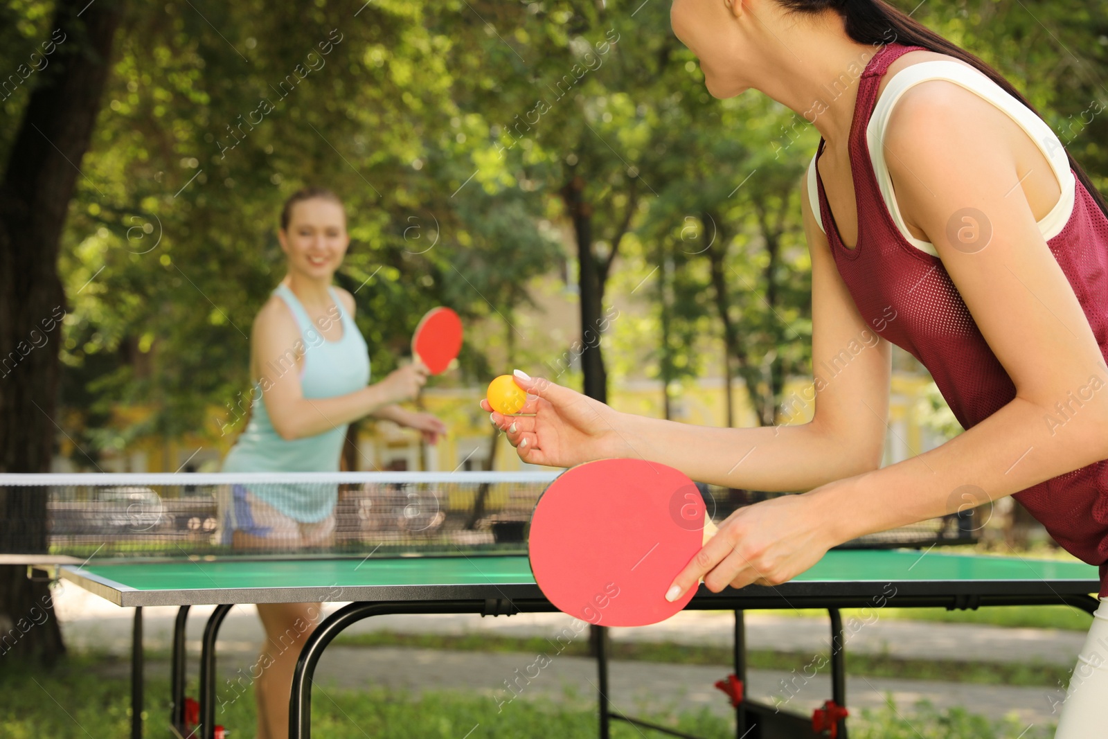 Young women playing ping pong in park, closeup Photo of Young women playing ping pong in park, closeup