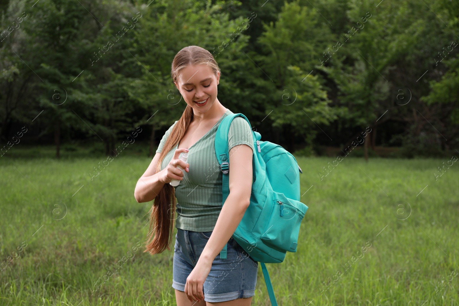 Woman applying insect repellent onto arm in park. Tick bites prevention Photo of Woman applying insect repellent onto arm in park. Tick bites prevention