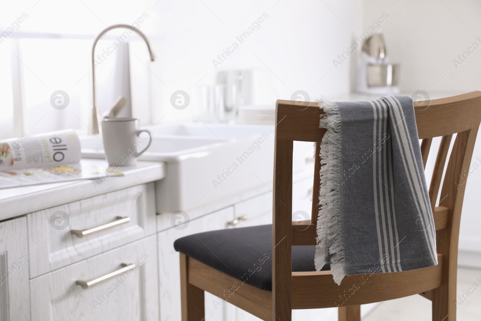 Dry towel on wooden chair in kitchen Photo of Dry towel on wooden chair in kitchen