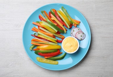 Different vegetables cut in sticks and dip sauce on light wooden table, top view Photo of Different vegetables cut in sticks and dip sauce on light wooden table, top view