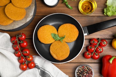 Delicious fried breaded cutlets, spices and vegetables on wooden table, flat lay Photo of Delicious fried breaded cutlets, spices and vegetables on wooden table, flat lay