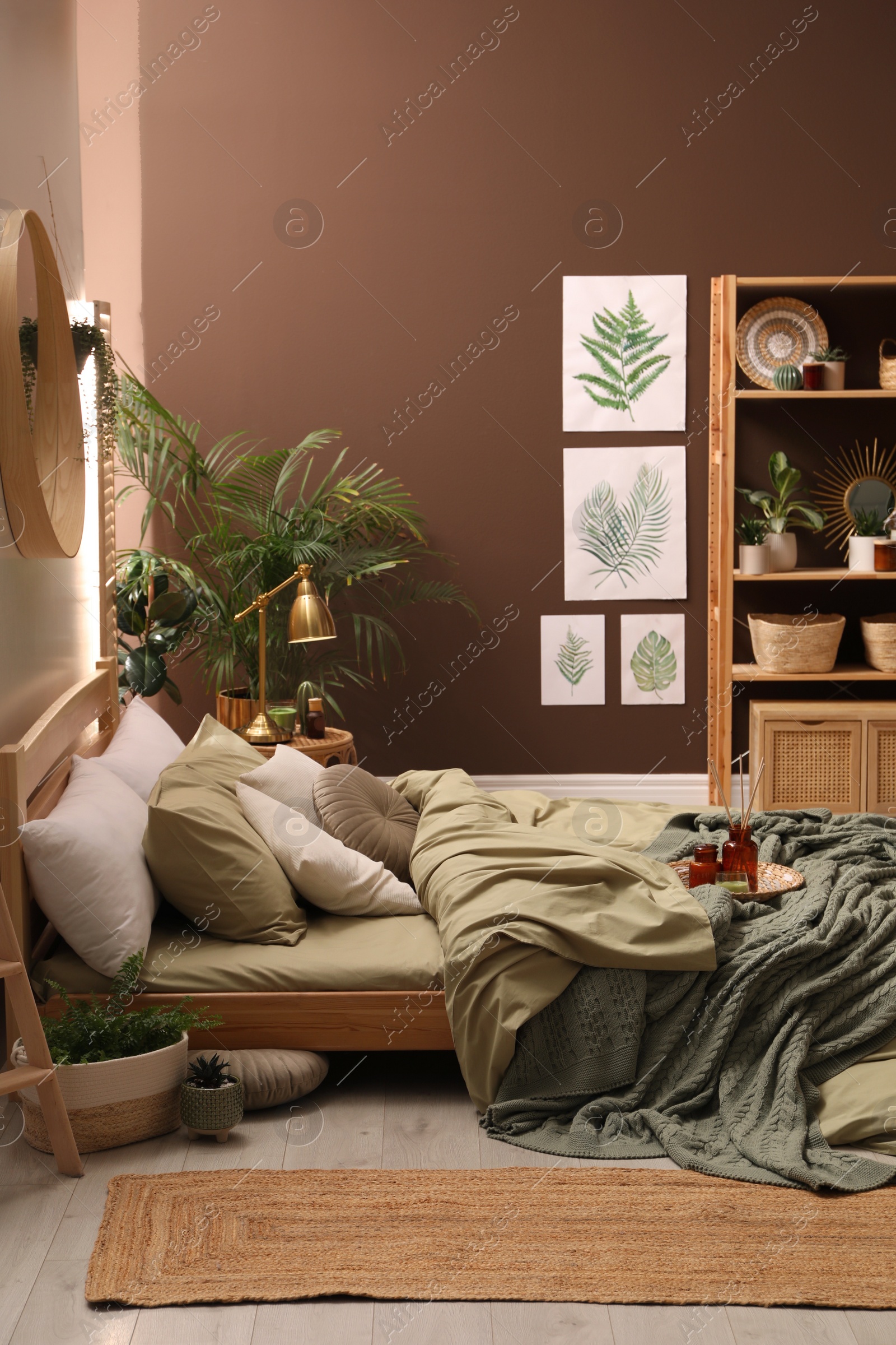 Stylish interior with large comfortable bed and potted plants Photo of Stylish interior with large comfortable bed and potted plants