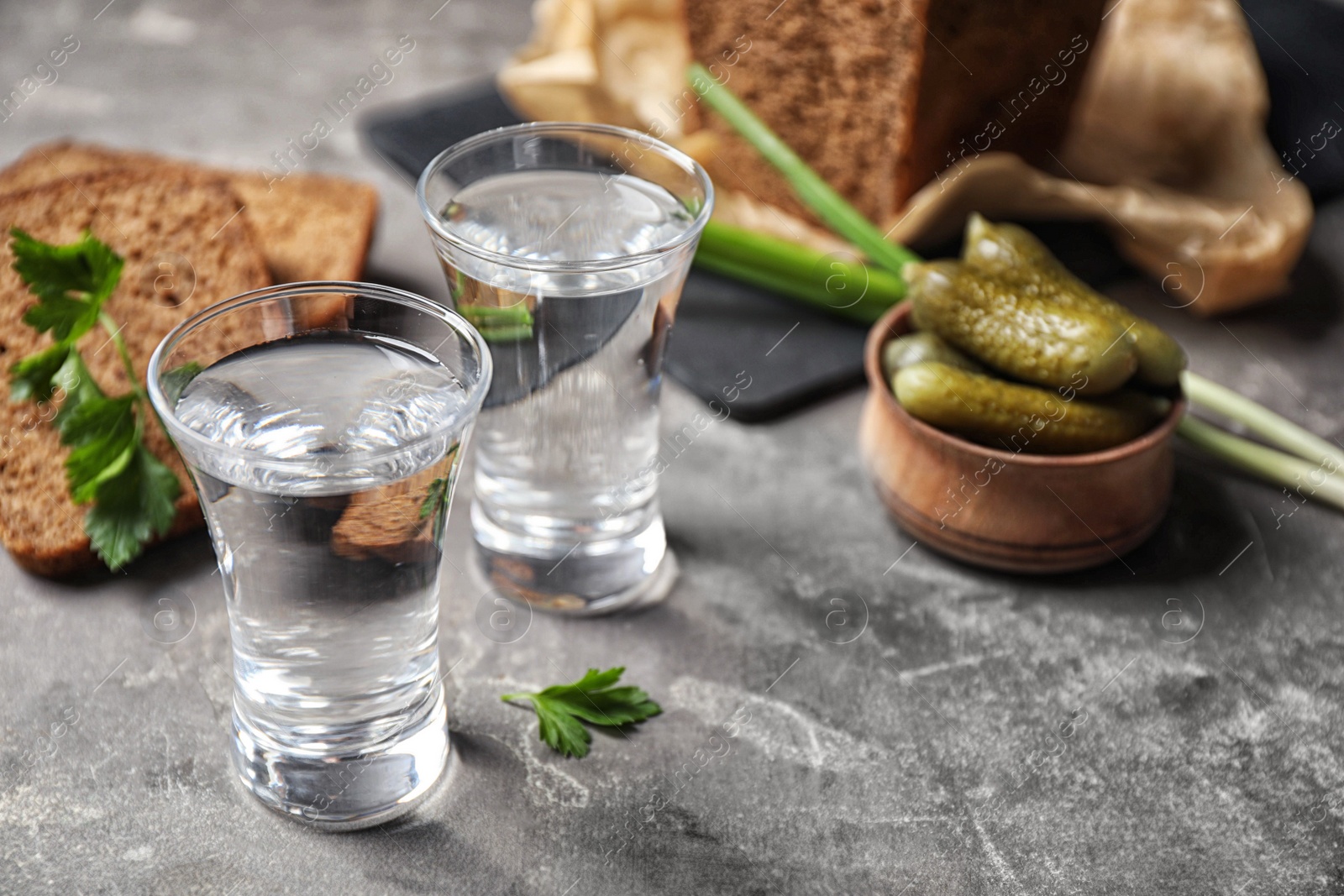Cold Russian vodka with snacks on grey table, closeup Photo of Cold Russian vodka with snacks on grey table, closeup