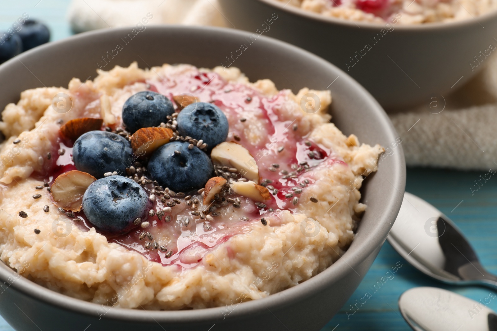 Tasty oatmeal porridge with toppings on light blue wooden table, closeup Photo of Tasty oatmeal porridge with toppings on light blue wooden table, closeup