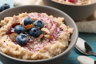 Tasty oatmeal porridge with toppings on light blue wooden table, closeup Photo of Tasty oatmeal porridge with toppings on light blue wooden table, closeup