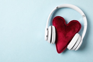 Modern headphones and red heart on turquoise background, flat lay with space for text. Listening love music songs Photo of Modern headphones and red heart on turquoise background, flat lay with space for text. Listening love music songs