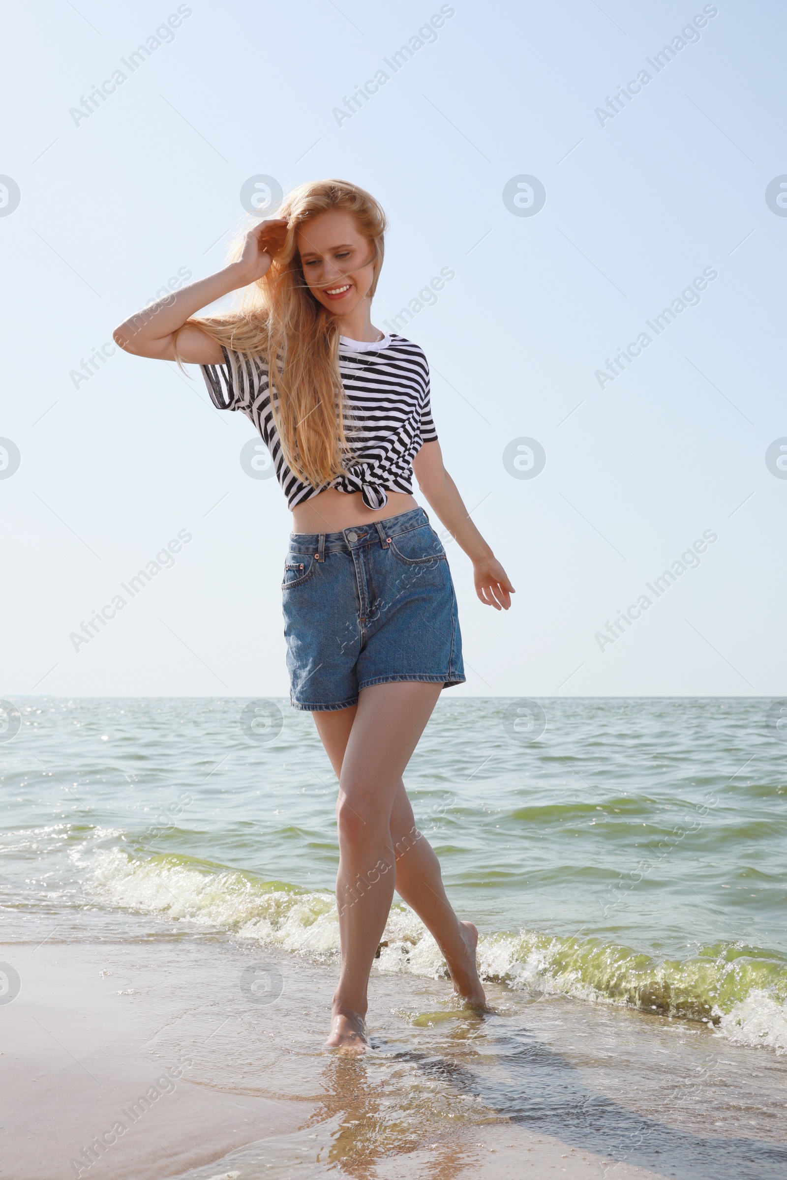 Beautiful young woman near sea on sunny day in summer Photo of Beautiful young woman near sea on sunny day in summer