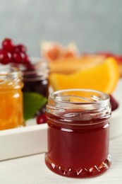 Open glass jar of sweet jam on white wooden table, closeup. Space for text Photo of Open glass jar of sweet jam on white wooden table, closeup. Space for text