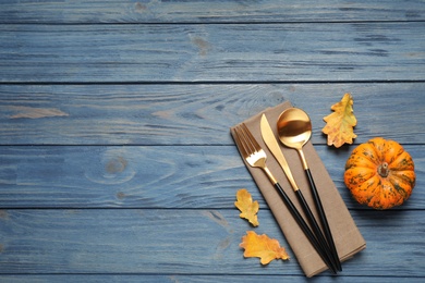 Cutlery, autumn leaves and pumpkin on blue wooden table, flat lay with space for text. Thanksgiving Day Photo of Cutlery, autumn leaves and pumpkin on blue wooden table, flat lay with space for text. Thanksgiving Day