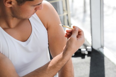 Sportsman injecting himself in gym, closeup. Doping concept Photo of Sportsman injecting himself in gym, closeup. Doping concept