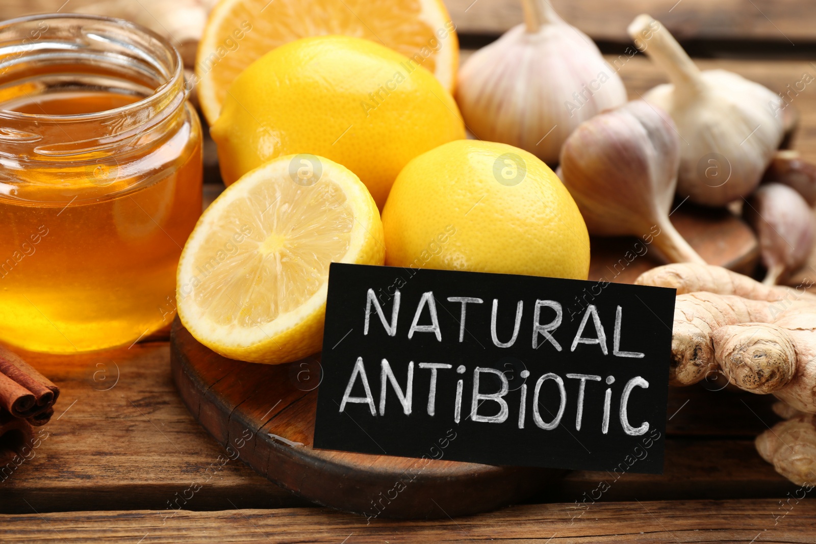Different fresh products and card with phrase Natural Antibiotic on wooden table, closeup Photo of Different fresh products and card with phrase Natural Antibiotic on wooden table, closeup