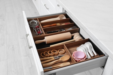Open drawer with utensil set indoors. Order in kitchen Photo of Open drawer with utensil set indoors. Order in kitchen