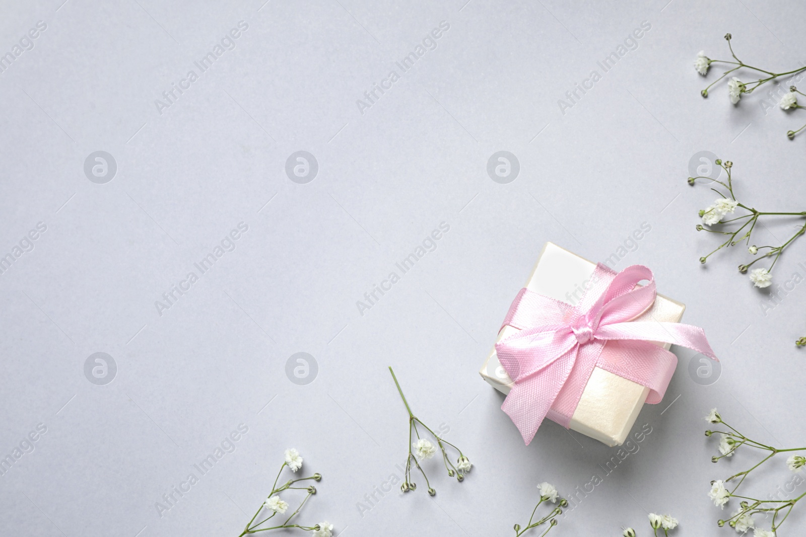 Flat lay composition with flowers and gift on light grey background, space for text. Happy Mother's day Photo of Flat lay composition with flowers and gift on light grey background, space for text. Happy Mother's day