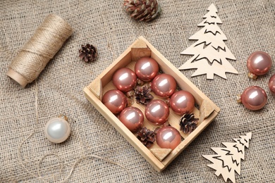 Composition with beautiful Christmas baubles and wooden crate on sacking, above view Photo of Composition with beautiful Christmas baubles and wooden crate on sacking, above view