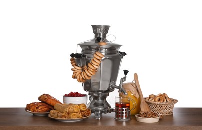 Traditional Russian samovar with treats on wooden table against white background Photo of Traditional Russian samovar with treats on wooden table against white background