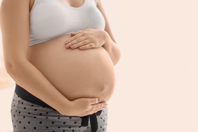 Pregnant woman after application of body cream on blurred background, closeup Photo of Pregnant woman after application of body cream on blurred background, closeup