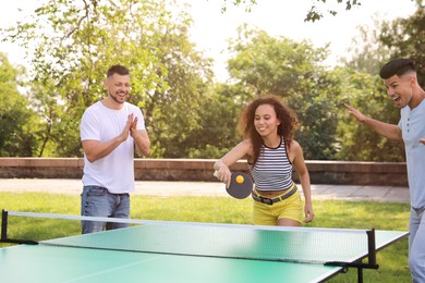 Friends playing ping pong outdoors on summer day Photo of Friends playing ping pong outdoors on summer day