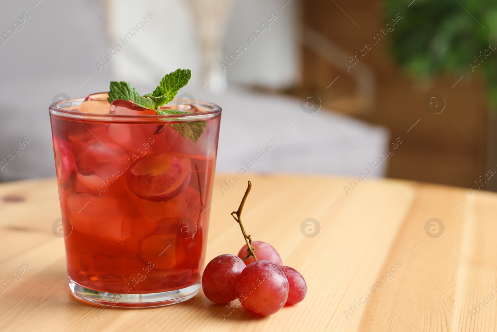 Refreshing drink with soda water, grapes, ice and mint on wooden table indoors. Space for text Photo of Refreshing drink with soda water, grapes, ice and mint on wooden table indoors. Space for text