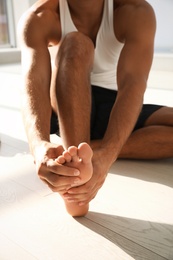 Man suffering from foot pain indoors, closeup Photo of Man suffering from foot pain indoors, closeup
