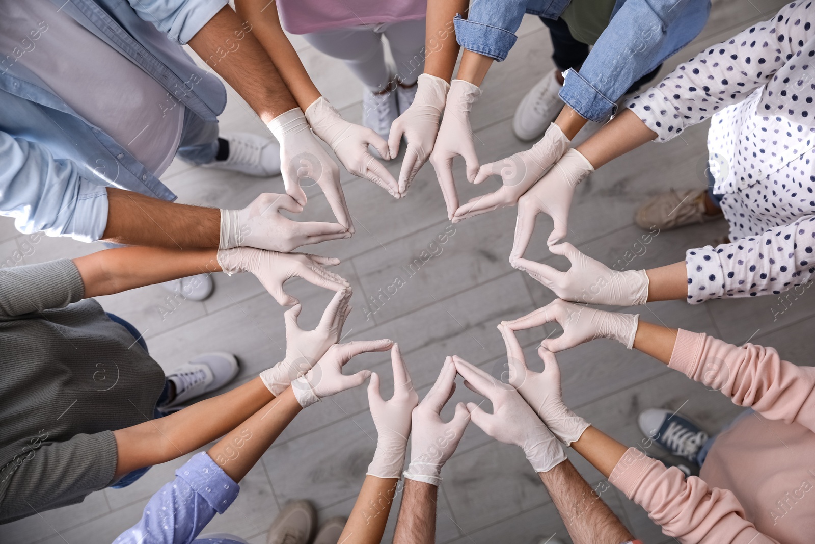 People in white medical gloves showing hearts with fingers indoors, top view Photo of People in white medical gloves showing hearts with fingers indoors, top view