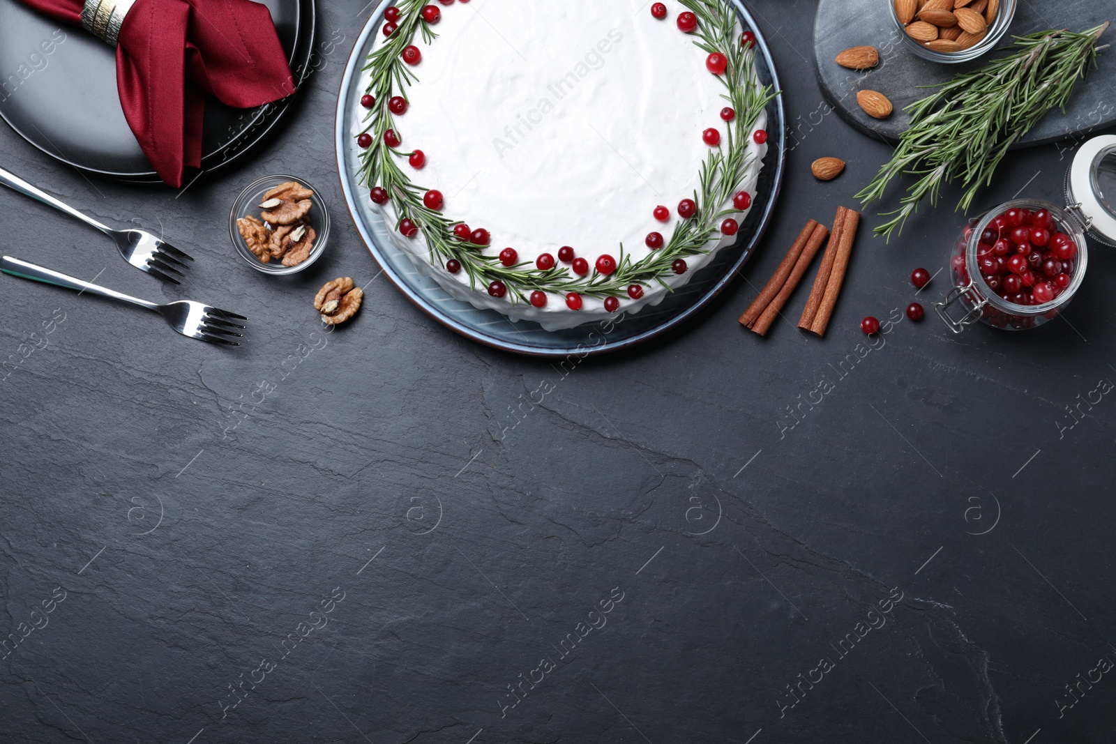 Flat lay composition with traditional Christmas cake and different ingredients on dark table, space for text Photo of Flat lay composition with traditional Christmas cake and different ingredients on dark table, space for text