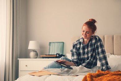 Young woman choosing vinyl disc to play music with turntable in bedroom Photo of Young woman choosing vinyl disc to play music with turntable in bedroom