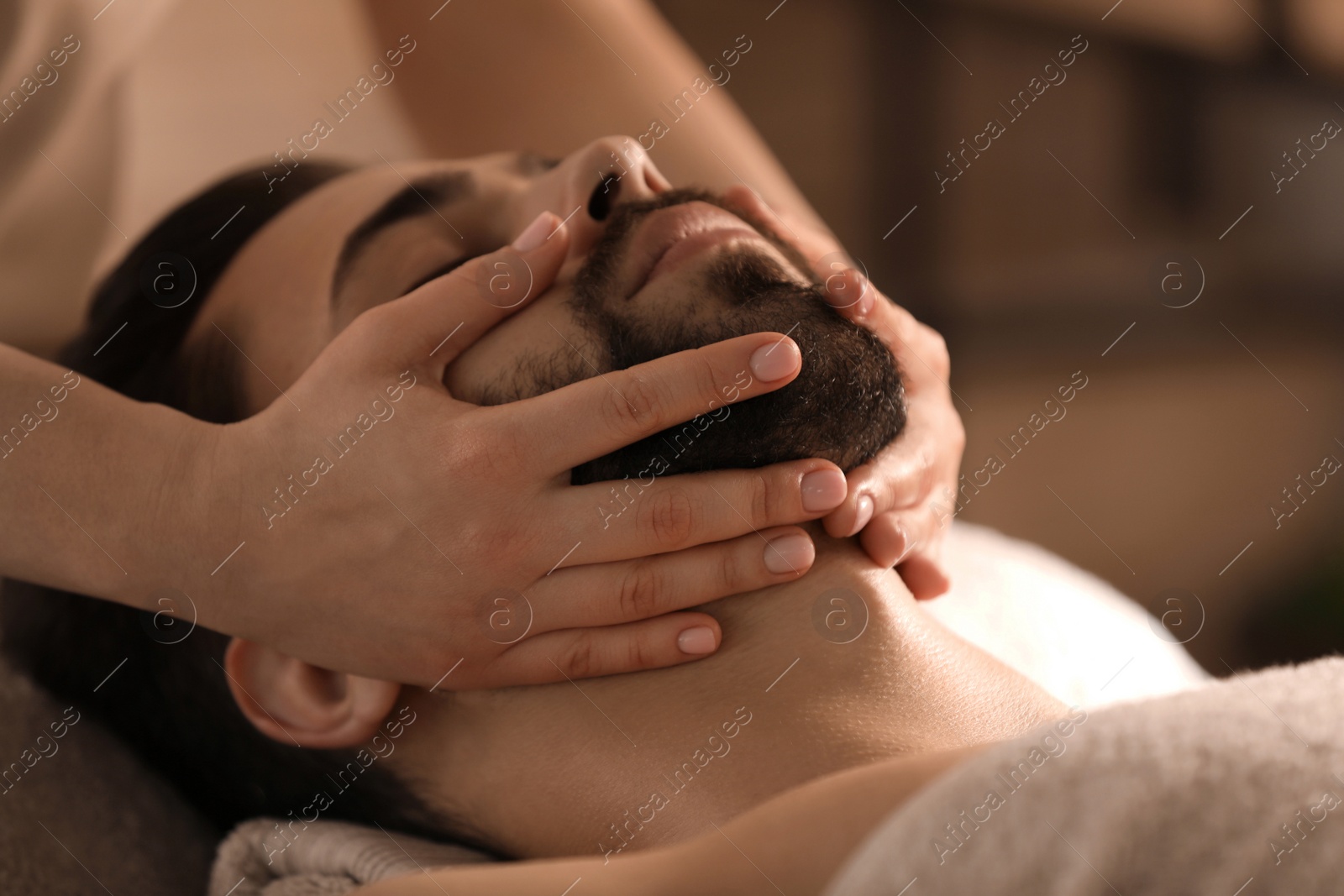 Young man receiving facial massage in beauty salon, closeup Photo of Young man receiving facial massage in beauty salon, closeup