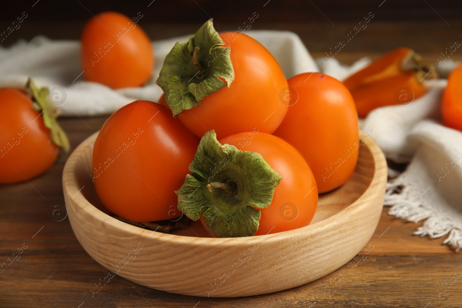 Tasty ripe persimmons on wooden table, closeup Photo of Tasty ripe persimmons on wooden table, closeup