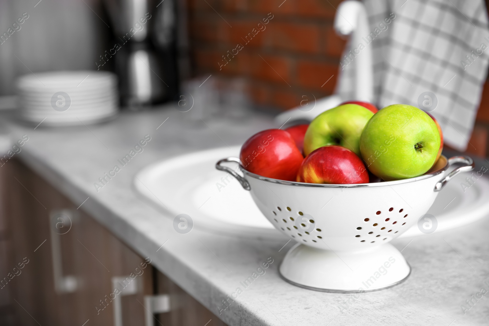 Colander with ripe apples in kitchen Photo of Colander with ripe apples in kitchen