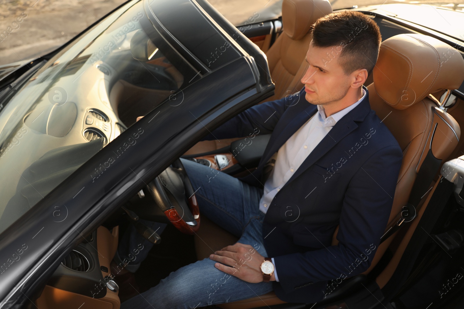 Young businessman in luxury convertible car outdoors Photo of Young businessman in luxury convertible car outdoors