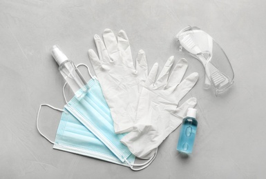 Flat lay composition with medical gloves, masks and hand sanitizers on grey background Photo of Flat lay composition with medical gloves, masks and hand sanitizers on grey background