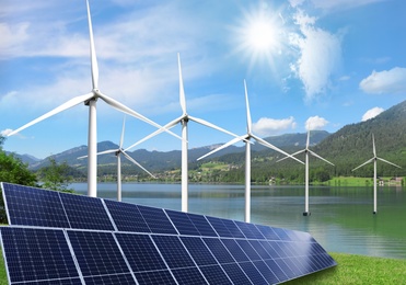 Alternative energy sources. Wind turbines installed in water near bank with solar panels Image of Alternative energy sources. Wind turbines installed in water near bank with solar panels