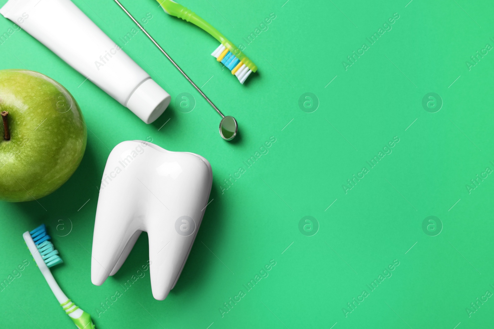 Flat lay composition with toothbrushes and holder on green background, space for text Photo of Flat lay composition with toothbrushes and holder on green background, space for text