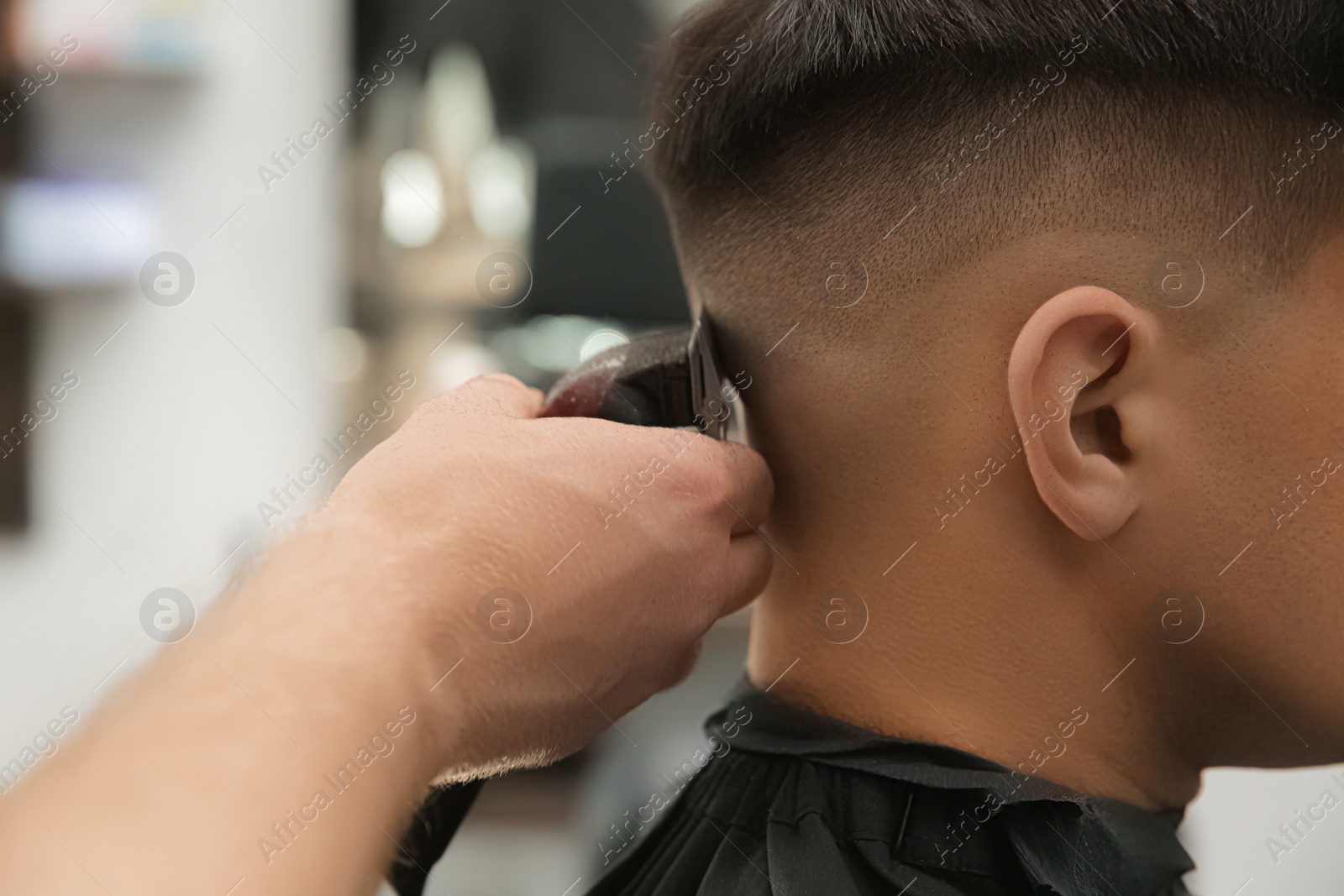 Professional barber making stylish haircut in salon, closeup Photo of Professional barber making stylish haircut in salon, closeup