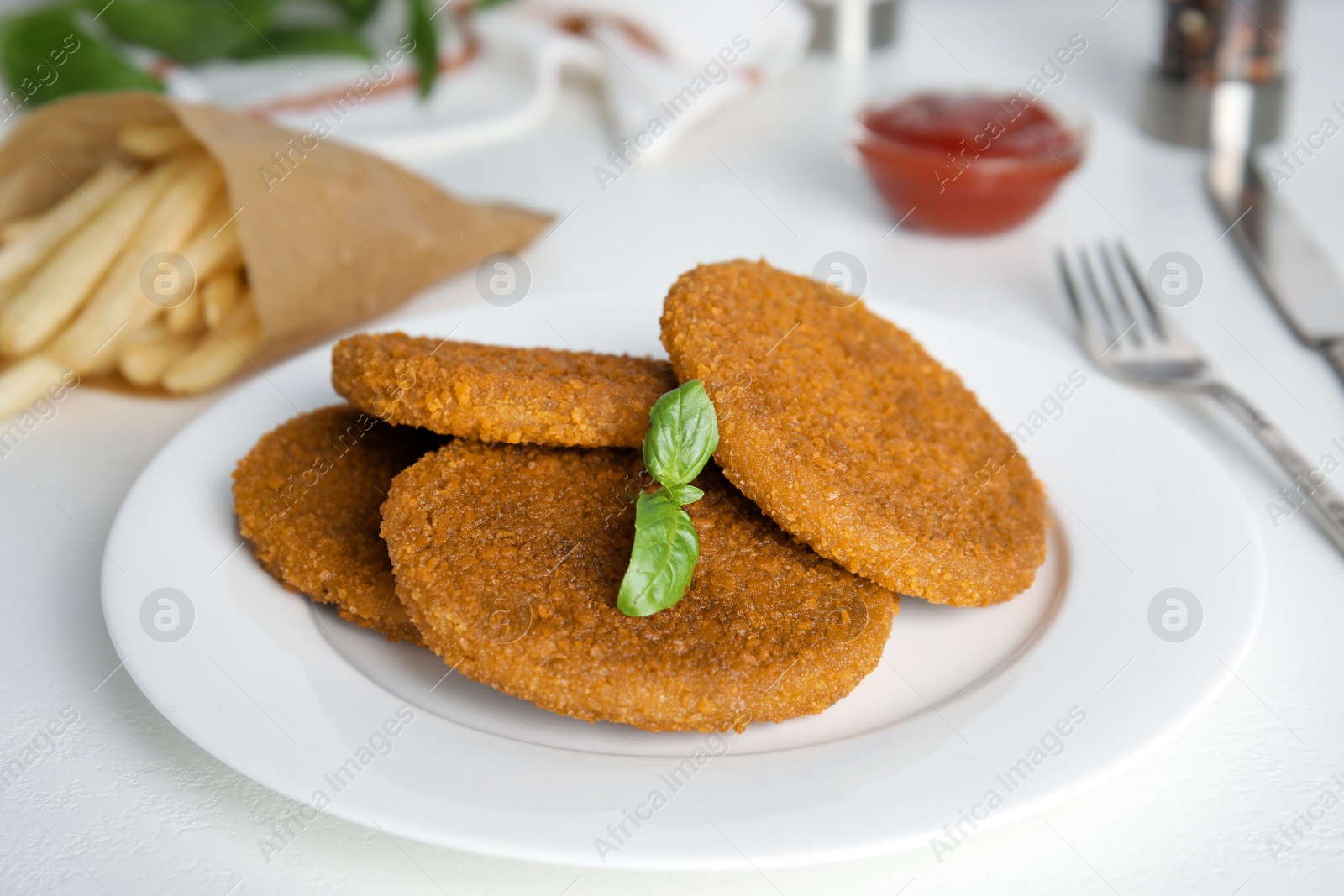 Photo of Delicious fried breaded cutlets served on white table, closeup