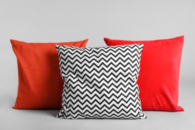 Different stylish soft pillows on grey background Photo of Different stylish soft pillows on grey background