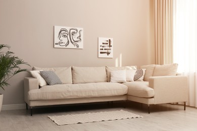 Stylish living room interior with modern comfortable sofa, plant and pictures Photo of Stylish living room interior with modern comfortable sofa, plant and pictures
