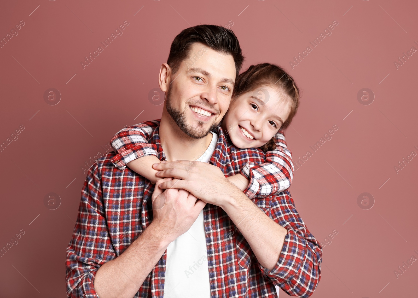 Dad and his daughter hugging on color background. Father's day celebration Photo of Dad and his daughter hugging on color background. Father's day celebration