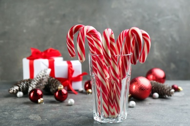 Many sweet candy canes in glass on grey table. Traditional Christmas treat Photo of Many sweet candy canes in glass on grey table. Traditional Christmas treat