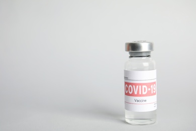 Vial with coronavirus vaccine on light background, space for text Photo of Vial with coronavirus vaccine on light background, space for text