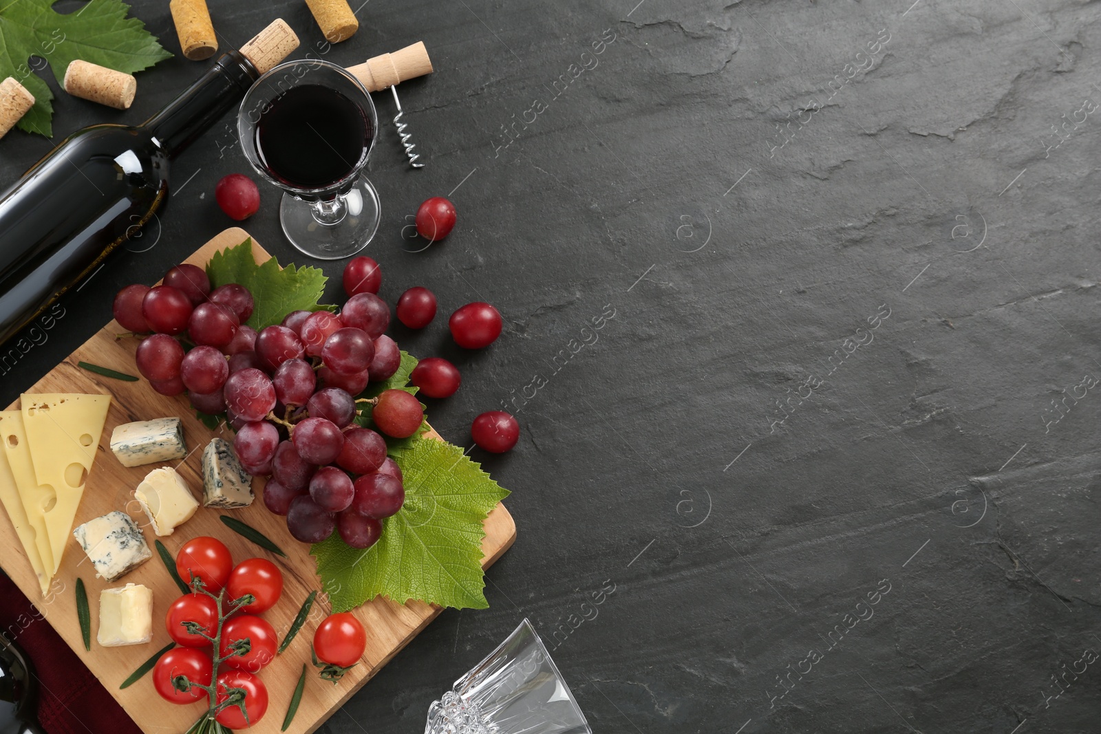 Tasty red wine and snacks on black table, flat lay. Space for text Photo of Tasty red wine and snacks on black table, flat lay. Space for text