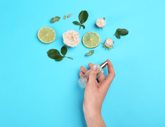 Top view of woman spraying perfume on blue background, flowers and lime representing aroma Photo of Top view of woman spraying perfume on blue background, flowers and lime representing aroma