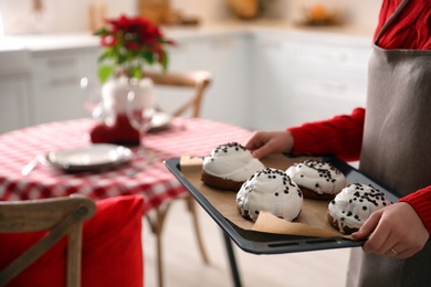 Woman with sweet buns for Christmas dinner in kitchen, closeup Photo of Woman with sweet buns for Christmas dinner in kitchen, closeup