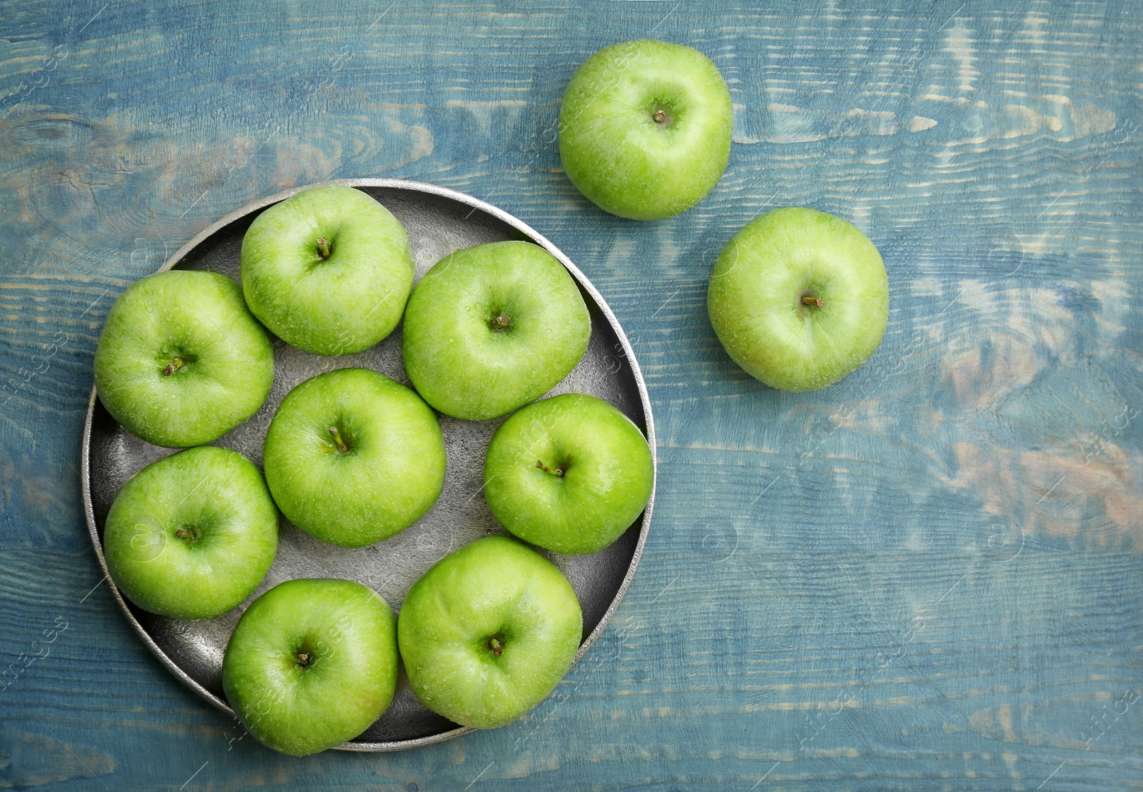 Plate with fresh green apples on wooden background Photo of Plate with fresh green apples on wooden background