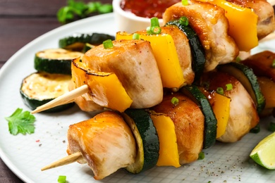 Delicious chicken shish kebabs with vegetables on plate, closeup Photo of Delicious chicken shish kebabs with vegetables on plate, closeup