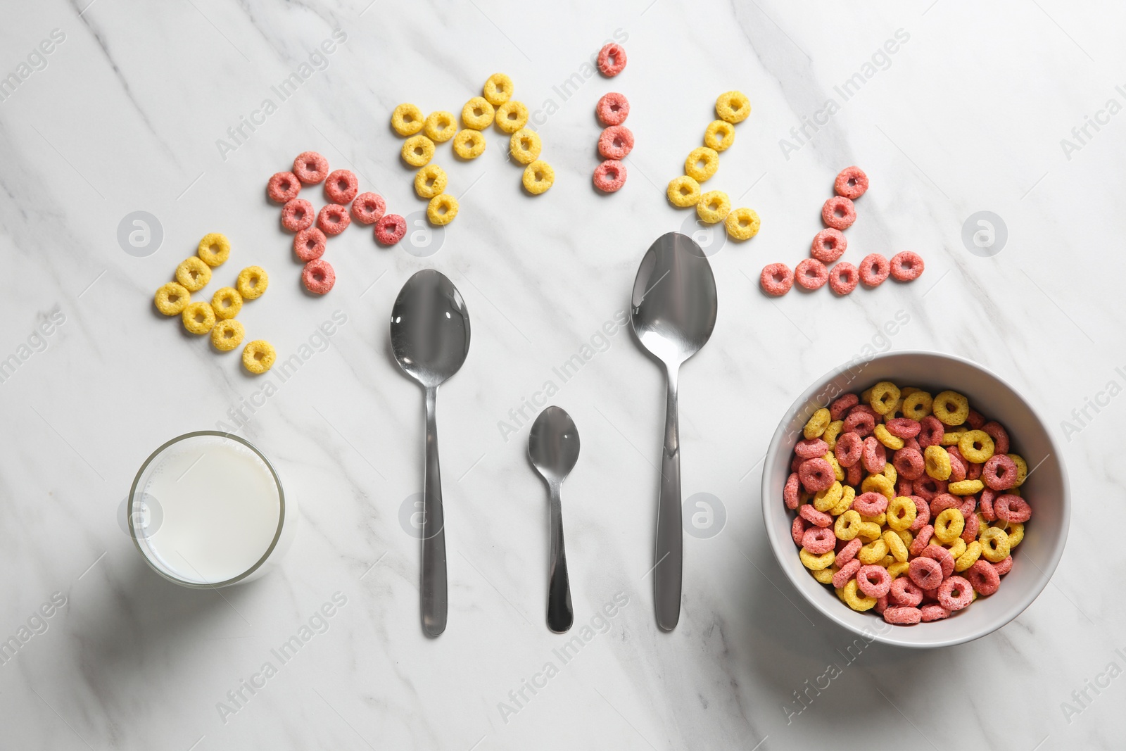 Word Family, cereal rings, milk and different spoons on white marble table, flat lay Photo of Word Family, cereal rings, milk and different spoons on white marble table, flat lay