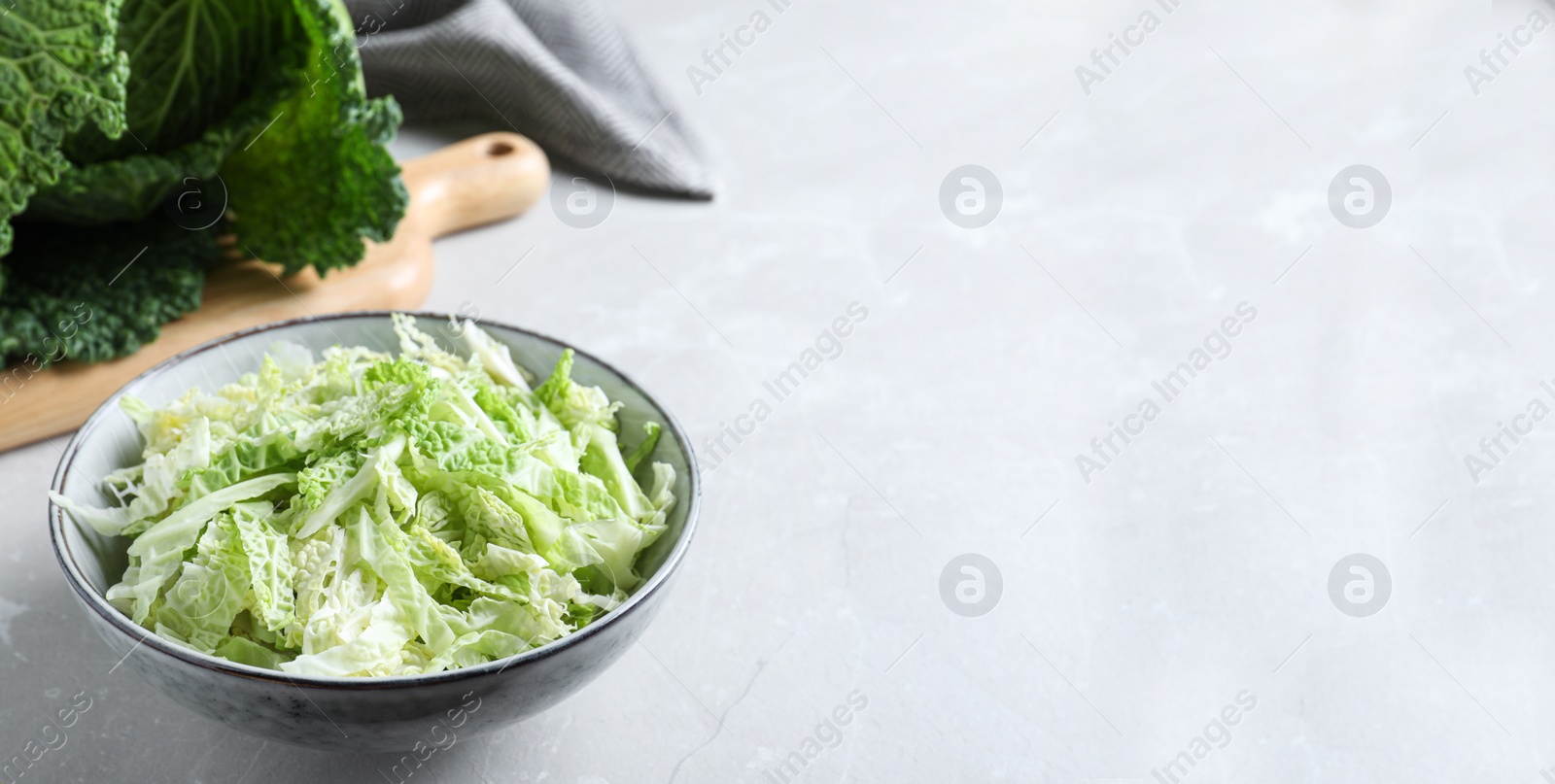 Cut fresh savoy cabbage in bowl on light table, closeup. Space for text Photo of Cut fresh savoy cabbage in bowl on light table, closeup. Space for text
