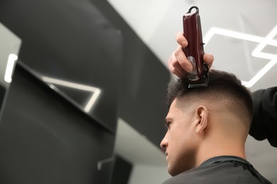 Professional barber making stylish haircut in salon, closeup Photo of Professional barber making stylish haircut in salon, closeup